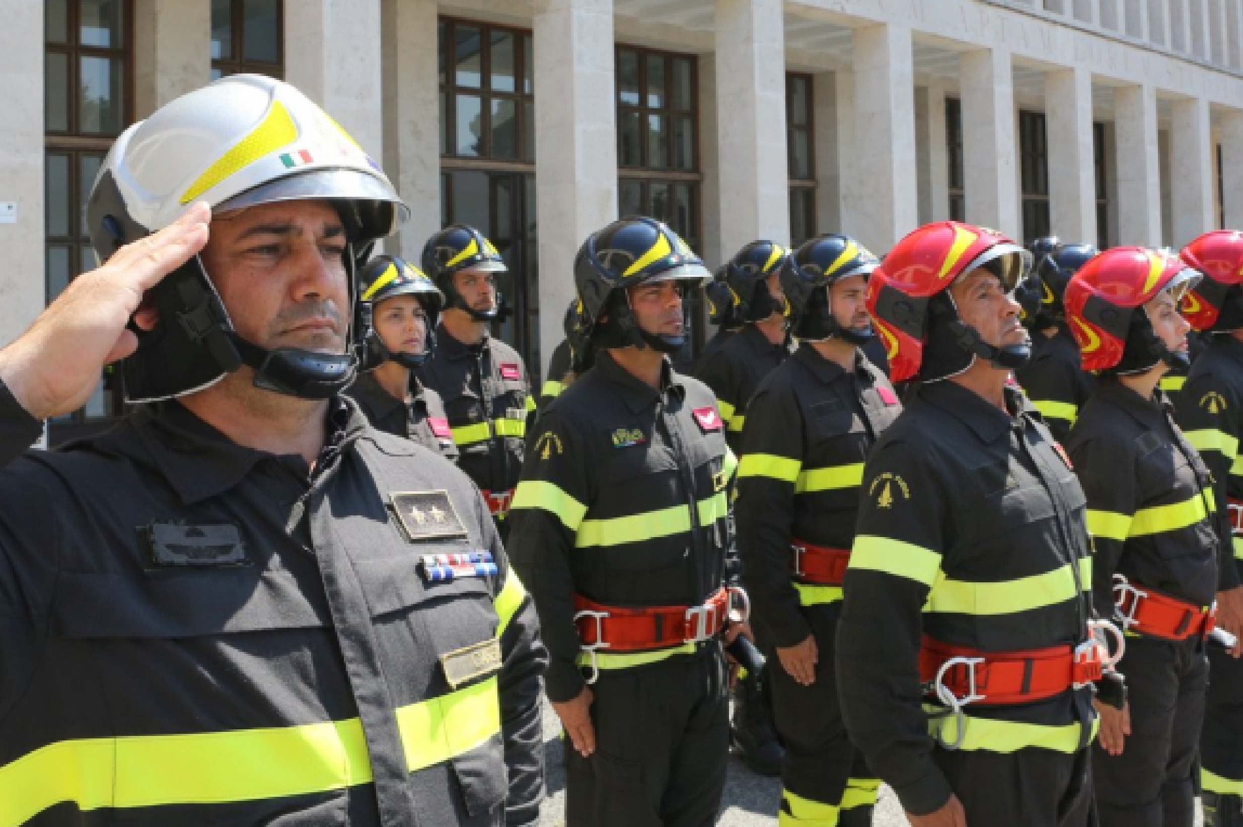 foto di una dozzina di vigili del fuoco in divisa sull'attenti